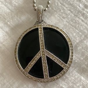 Black enamel peace sign with crystals. 15” chain. 16-1/2” to bottom of pendant.